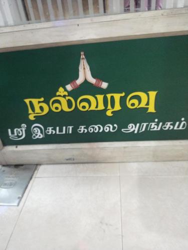 ein Schild für einen Laden mit einer Person drauf. in der Unterkunft Ilamathi hostel in Chennai