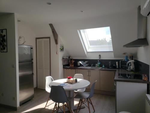 une petite cuisine avec une table et des chaises. dans l'établissement Le charmillon, Appartement cosi avec double garage, à Mancey