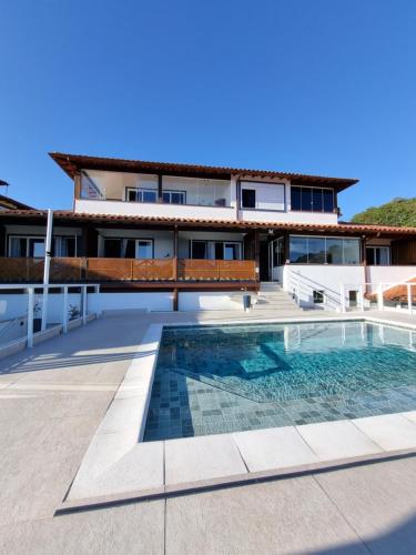 Pousada Santorini في بوزيوس: بيت فيه مسبح قدام بيت