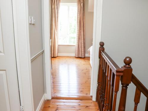 a hallway with a staircase and a window at No 1 Mariner's Court in Rosslare