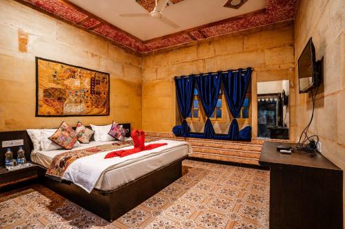 kings villa Jaisalmer في جيلسامر: غرفة نوم بسرير وتلفزيون بشاشة مسطحة