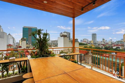 a balcony with a wooden table and a view of the city at NB APARTMENT - KIM MA in Hanoi