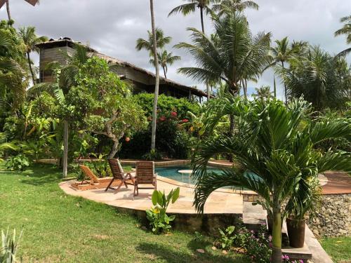 un resort con piscina e palme di Casa Cacau a São Miguel do Gostoso