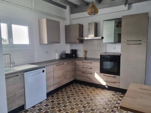 a kitchen with white appliances and wooden cabinets at Chez Cédric et Mélissa maison Lou Milhòc en Béarn in Os-Marsillon