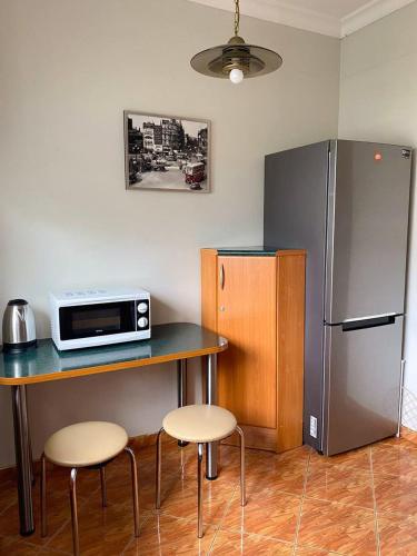 a kitchen with a table with a microwave and a refrigerator at HALBY rooms Nowolipki 15 in Warsaw