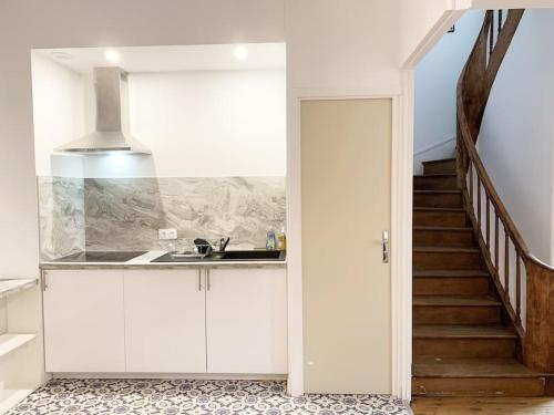 una cocina con armarios blancos y una escalera en Le Grand Cognet by iZiLi *Charme&Spacieux*Centre*, en Châtellerault