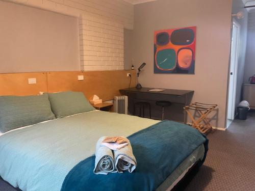 a bedroom with a large bed with a desk and a desk at Treetops Silvan Valley Lodge - suite 3 in Silvan