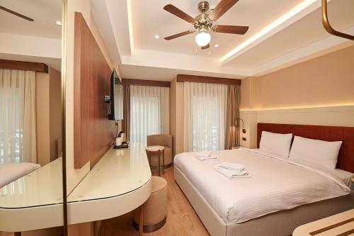a bedroom with a bed and a ceiling fan at Saratoga Hotel Sultanahmet in Istanbul