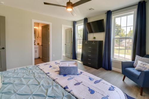 a bedroom with a large bed and a blue chair at Spacious Yard, Games and Fire Pit Grove Home Rental in Grove