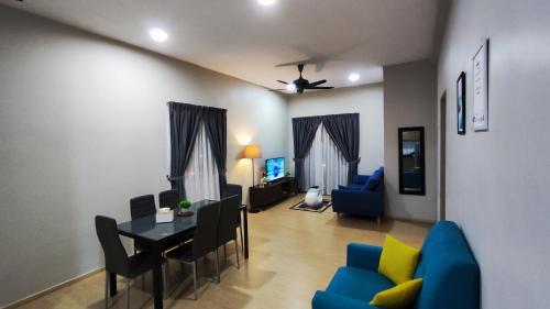 a living room with a table and a dining room at A ONE Holiday Apartment in Tanah Rata