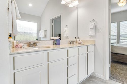 a white bathroom with a sink and a mirror at Coronilla Bend - Main Home in Austin