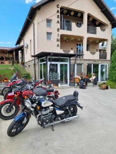 rząd motocykli zaparkowany przed budynkiem w obiekcie Casa Sima w mieście Curtea de Argeş