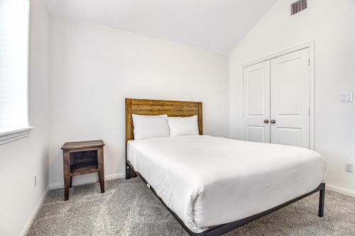 um quarto branco com uma cama e uma mesa em Coronilla Bend - Main Home em Austin