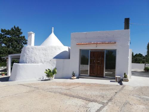a white house with a door and a window at Holiday Home Trullo Antico in Ostuni