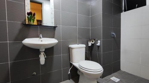 a bathroom with a toilet and a sink at A ONE Holiday Apartment in Tanah Rata