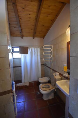 a bathroom with two toilets and a sink at Cabañas Río Molle in Tafí del Valle