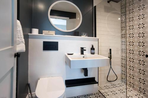 ein Badezimmer mit Waschbecken, Toilette und Spiegel in der Unterkunft Seaside House in Beadnell