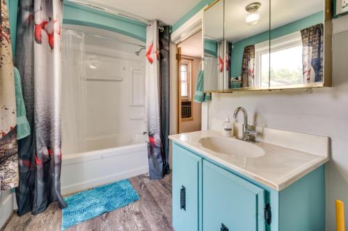 uma casa de banho com um lavatório e um chuveiro em Cozy Iowa Getaway with Patio and Fenced-In Yard! em Dyersville