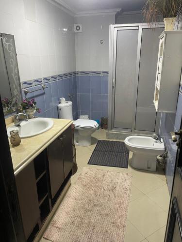 een badkamer met 2 wastafels, een toilet en een douche bij marina beach mohammedia in Mohammedia
