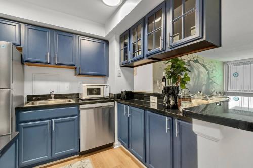 una cocina con armarios azules y fregadero en A WELL SEASONED APT IN TOWSON MD.WALKING DISTANCE TO EVERYTHING., en Towson