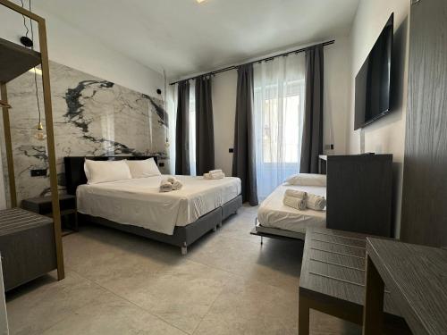 1 dormitorio con 2 camas y ventana grande en Dolmen Guest House, en Alghero