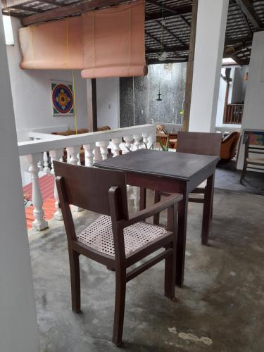 a wooden table and chairs in a room at Shoba Traveller's Tree in Galle