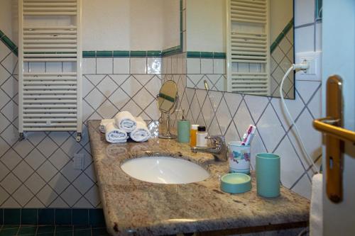 eine Badezimmertheke mit einem Waschbecken und einem Spiegel in der Unterkunft Hotel Sunset Green in Ischia