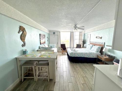 1 dormitorio con 1 cama y escritorio con mesa en I Need A Vacay Now! Remodeled Studio en Daytona Beach