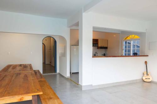 a living room with a wooden table and a guitar at Sea Wolf Hostel - Lagoa da Conceição in Florianópolis