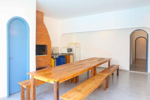uma mesa de madeira num quarto com uma cozinha em Sea Wolf Hostel - Lagoa da Conceição em Florianópolis