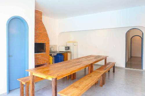 a wooden table in a room with a kitchen at Sea Wolf Hostel - Lagoa da Conceição in Florianópolis