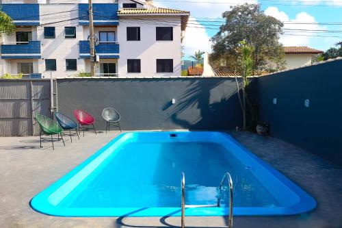 a swimming pool in a backyard with chairs around it at Sea Wolf Hostel - Lagoa da Conceição in Florianópolis