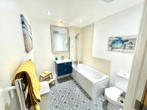 a bathroom with a tub and a sink and a toilet at Cosy 1 bedroom apartment with balcony near Chiswick in London