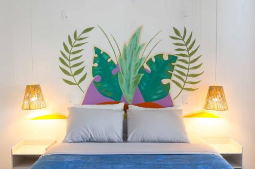 a bedroom with a bed with a large plant on the wall at Sea Wolf Hostel - Lagoa da Conceição in Florianópolis