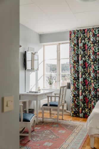 a dining room with a table and chairs and a window at Slottsparken Motel in Huskvarna