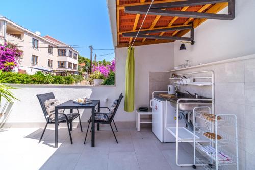 eine kleine Küche mit einem Tisch und Stühlen auf dem Balkon in der Unterkunft Rooms Anna in Milna