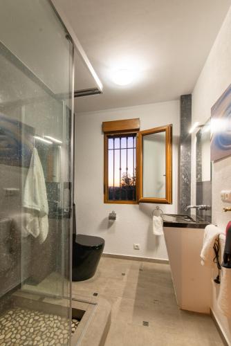 a bathroom with a glass shower and a black tub at Paraíso Villa de Granada in Dúrcal