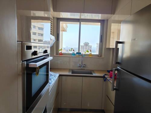 a small kitchen with a sink and a refrigerator at Trendy1BR+smart kitchen +Living room+1.5 toilets in Mumbai
