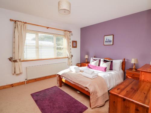 a bedroom with a large bed and a window at Hook Head Hideaway 