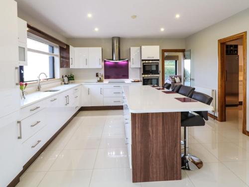 a kitchen with white cabinets and a large island at Upper Killult in Cashel Hill