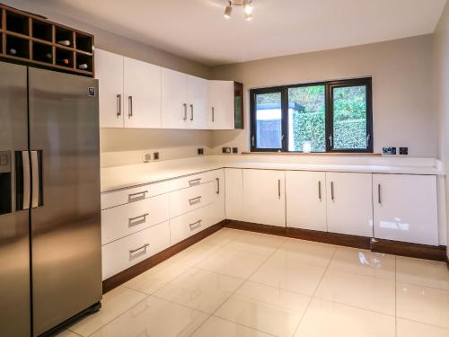 a kitchen with white cabinets and a stainless steel refrigerator at Upper Killult in Cashel Hill