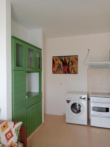 a kitchen with green cabinets and a washing machine at Farfalla in Vila do Porto