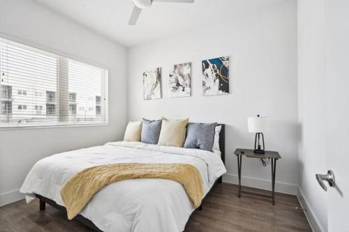 a white bedroom with a bed and a window at Luxurious 1BD apt in Austin suburb in Pflugerville