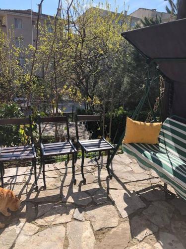 dwie ławki i kot siedzący na patio w obiekcie Yazlık bahçe katı daire w mieście Armutlu