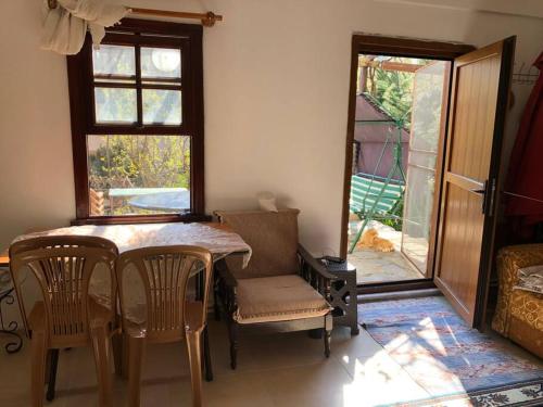 jadalnia ze stołem i krzesłami oraz oknem w obiekcie Yazlık bahçe katı daire w mieście Armutlu