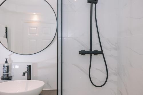 a bathroom with a shower with a sink and a mirror at Muthu Belstead Brook Hotel in Ipswich