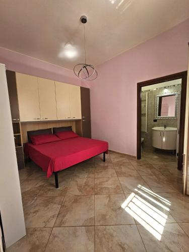 a bedroom with a red bed and a bath tub at Pink Place in Policoro