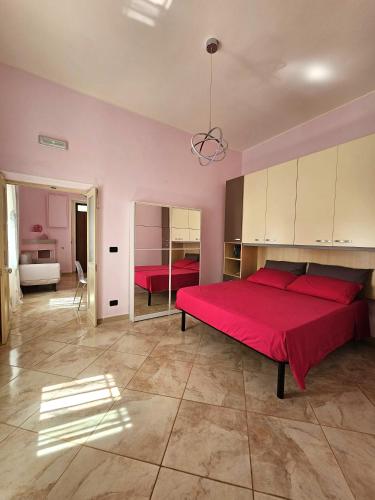 ein Schlafzimmer mit einem großen roten Bett in einem Zimmer in der Unterkunft Pink Place in Policoro