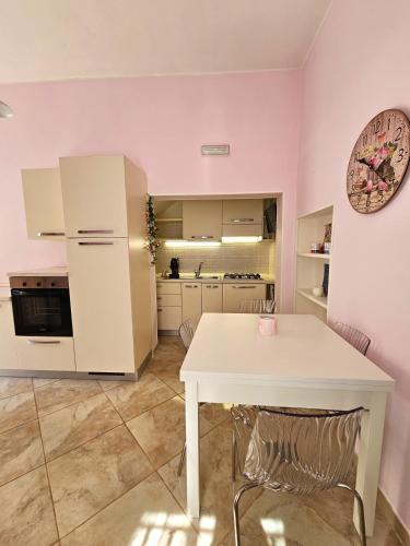 a kitchen with a white table and a white table at Pink Place in Policoro