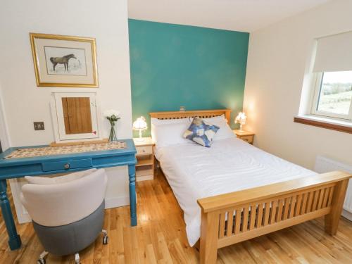 sypialnia z łóżkiem i niebieskim biurkiem w obiekcie The Derries 